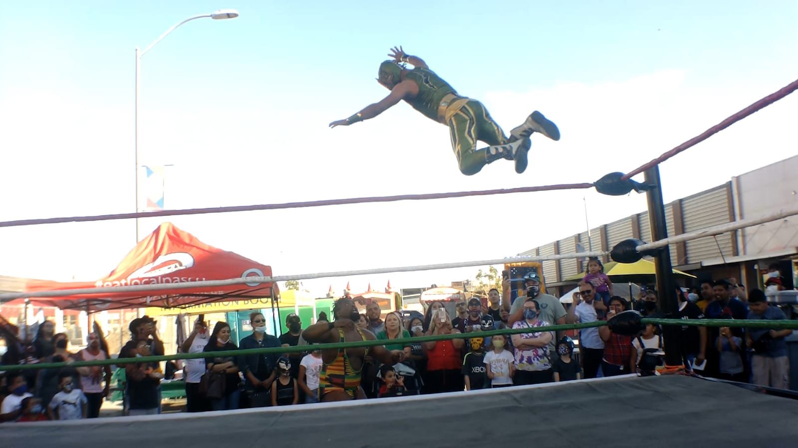 Luchador enmascarado en pleno vuelo sobre el público en La Terraza de Main Street, centro de Pasco, 2021