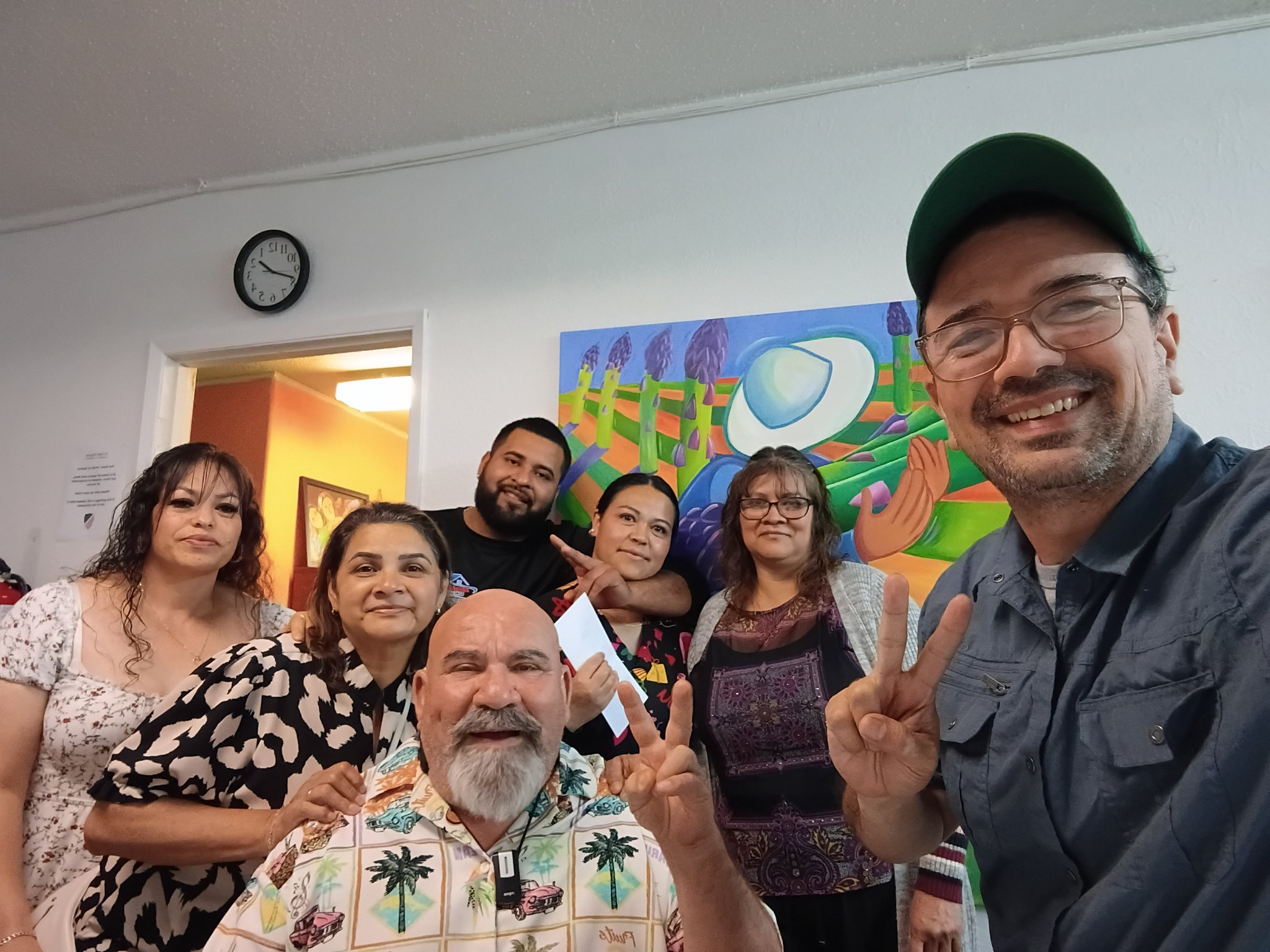 Gustavo con participantes del grupo cívico de Tu Voz, Tu Poder, frente a un mural comunitario